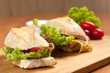 Tasty sandwiches with vegetables on a wooden table.