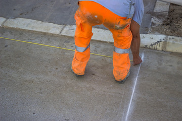 road paint worker with measuring tape
