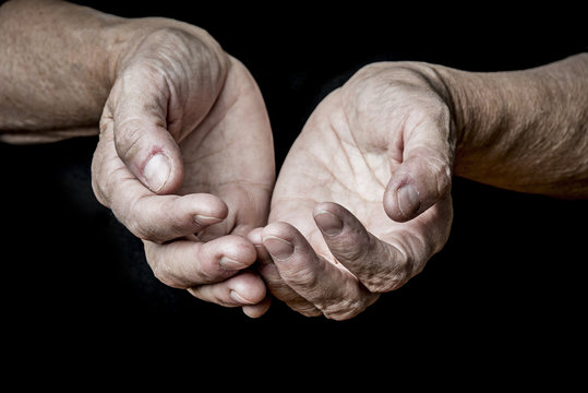 old elderly hands on a black background