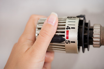 Woman Adjusting The Thermostat