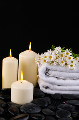 Spa feeling with candle , branch daisy ,towel ,pebbles