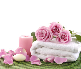 Obraz na płótnie Canvas pink rose and towel with candle on green mat
