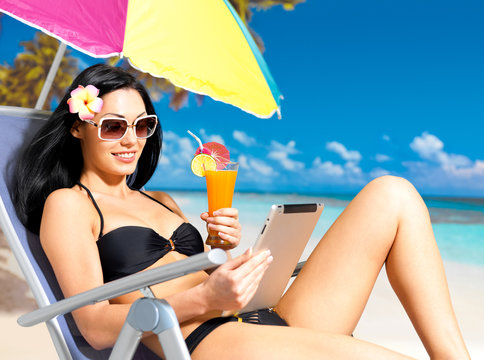 Happy Woman On The Beach With Ipad