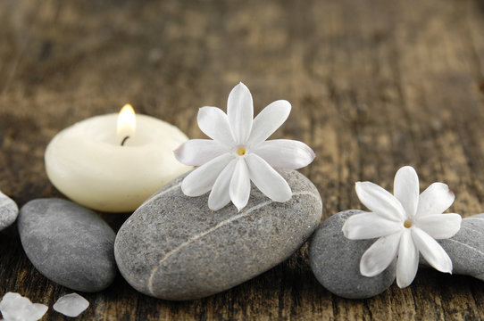 grey stones and spring flower, candle on old wood