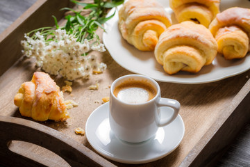 Flowers, croissant and coffee for breakfast