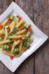 Pasta with vegetables on the table in a square plate top view