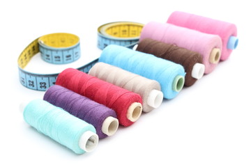 Fototapeta na wymiar Colorful spools of thread tape measure on white background