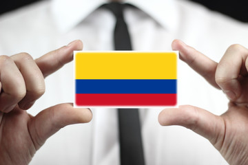 Businessman holding a business card with a Colombia Flag - obrazy, fototapety, plakaty
