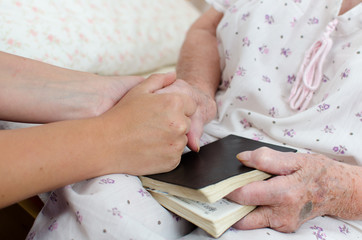 Young woman holding senior woman's hand