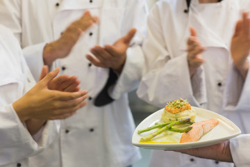 Obraz na płótnie Canvas Chefs applauding a salmon dish