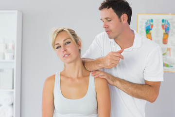 Fototapeta na wymiar Attractive physiotherapist massaging patients neck with elbow