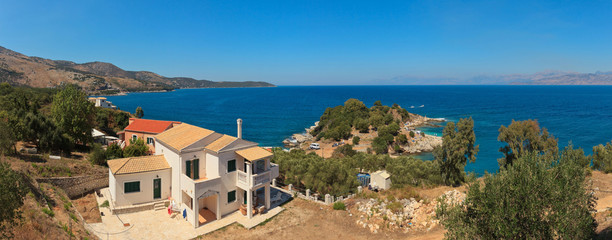 Naklejka premium Panoramic shot of a white house on the coast. Beautiful bay with