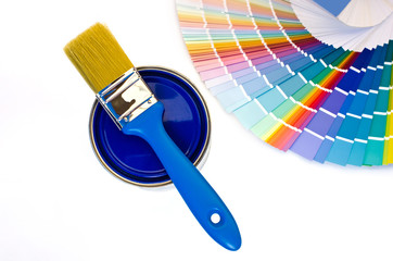 Can of blue paint with a brush and blue color swatches