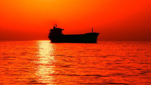Cargo ship in the sea at sunset