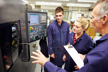 Engineer Teaching Apprentices To Use Computerized Lathe - obrazy, fototapety, plakaty