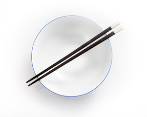 chopsticks in empty bowl isolated on a white background