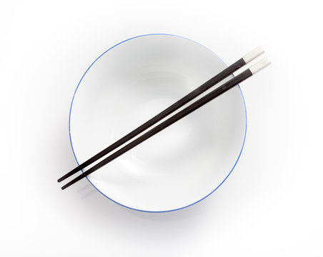 Chopsticks In Empty Bowl Isolated On A White Background