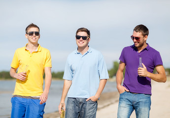 friends on the beach with bottles of drink