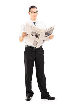Businessman standing and reading a newspaper