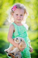 little girl with teddy bear outdoors