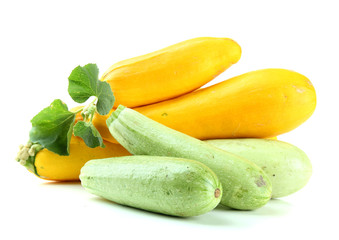 Raw yellow and green zucchini with leaves, isolated on white