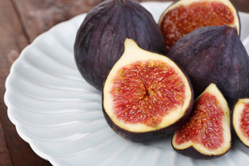 Ripe figs on plate wooden table close-up