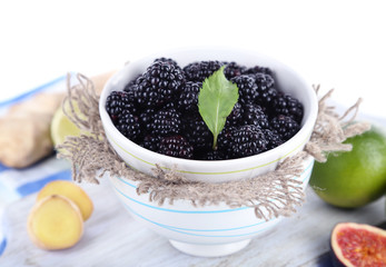 Blackberry in small bowl on board on napkin isolated on white
