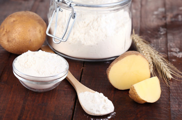 Starch in bowl and bank on wooden table close-up