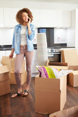 Woman Moving Into New Home Talking On Mobile Phone