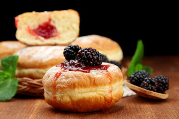Tasty donuts with berries on wooden table