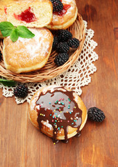 Obraz na płótnie Canvas Tasty donuts with chocolate and berries on wooden table