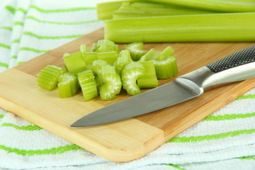 Fresh green celery on cutting board close-up