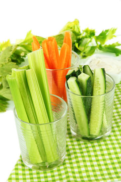 Fresh green celery with vegetables in glasses