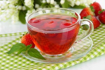 Delicious strawberry tea on table close-up