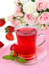 Delicious strawberry tea on table on white background