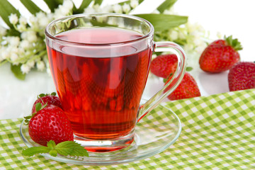 Delicious strawberry tea on table on white background