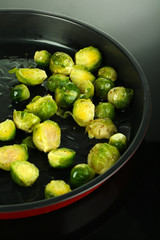Fresh brussels sprouts in pan on cooking surface close-up