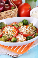 Stuffed tomatoes in bowl on wooden table close-up