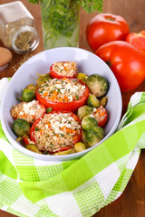 Stuffed tomatoes in bowl on wooden table close-up