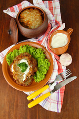 Potato pancakes in pot, on wooden background