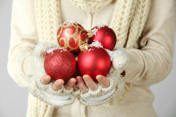Fototapeta na wymiar Female hands in mittens Christmas tree balls,