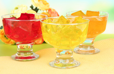 Tasty jelly cubes in bowls on table on light background
