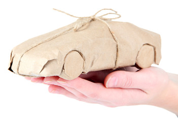 Obraz premium Woman hand holding a car wrapped in brown kraft paper, isolated