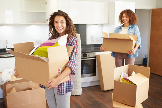 Two Women Moving Into New Home And Unpacking Boxes