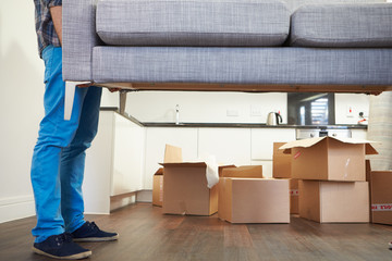 Close Up Of Man Carrying Sofa As He Moves Into New Home - obrazy, fototapety, plakaty