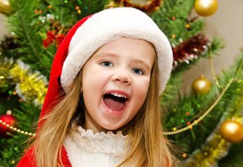 Cute little girl in santa hat with present have a christmas