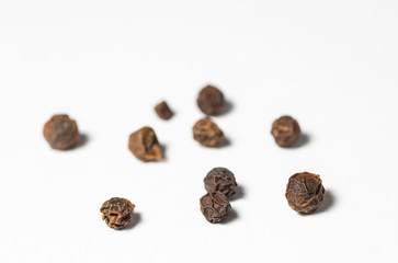 Pieces of black pepper on white.