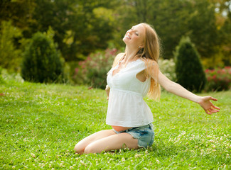Fototapeta premium pregnant woman lying on the soft grass