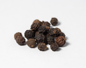 Pieces of black pepper on white.