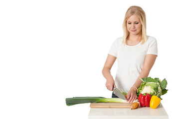Junge Frau beim Gemüse schneiden